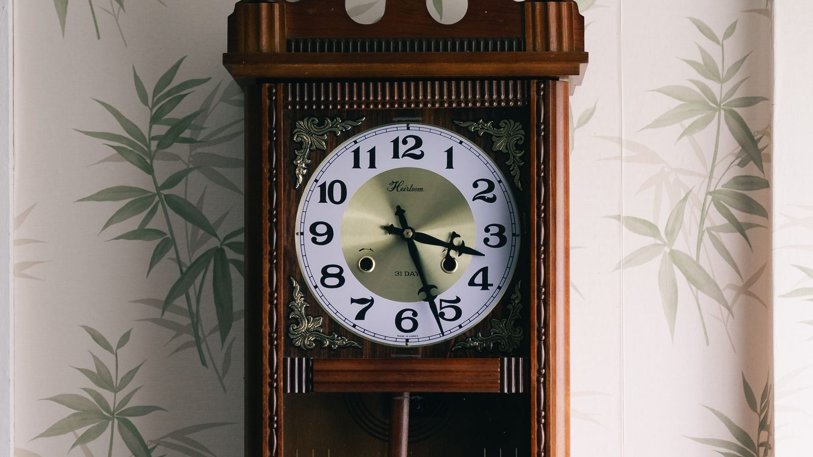 A room with a natural bamboo-motif textured wallcovering and a vintage wall clock